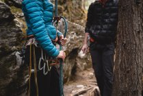 Couple se préparant à escalader la montagne rocheuse en forêt — Photo de stock