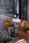 Керівник офісу за допомогою гарнітури віртуальної реальності на дивані в офісі — стокове фото