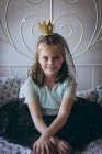 Menina feliz com tiara na cabeça no quarto — Fotografia de Stock