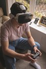 Man playing video game in virtual reality headset at home. — Stock Photo