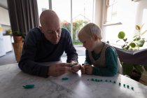 Father and son playing with clay in living room at home. — Stock Photo