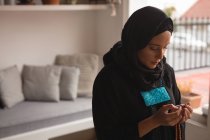 Mulher muçulmana orando com contas de oração em casa — Fotografia de Stock