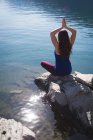 Жінка практикує йогу на скелі біля моря — стокове фото