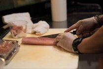 Chef filetagem de peixe na cozinha do restaurante em uma tábua de cortar — Fotografia de Stock
