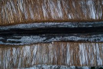 Pila di tronchi di legno tenuti lungo la strada durante l'inverno — Foto stock