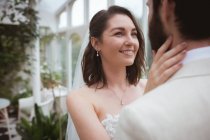 Primer plano de la novia sonriente mirando al novio - foto de stock