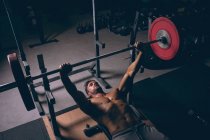 Soffitto di uomo muscoloso che si allena con il bilanciere nella sala fitness — Foto stock