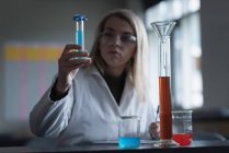 Adolescente expérimentant une solution chimique en laboratoire — Photo de stock