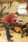 Jovem carpinteiro do sexo masculino trabalhando em oficina — Fotografia de Stock