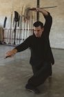 Combattant de karaté pratiquant les arts martiaux en studio de fitness . — Photo de stock