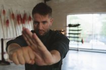 Боец карате практикующий боевые искусства в фитнес-студии . — стоковое фото