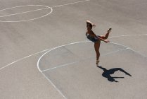 Jovem dançarina de balé dançando na quadra de basquete — Fotografia de Stock