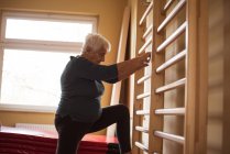 Старшая женщина делает упражнения в доме престарелых — стоковое фото