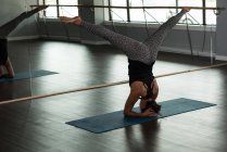 Mulher praticando ioga no tapete de exercício no estúdio de fitness . — Fotografia de Stock