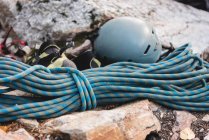 Vista ravvicinata di corda, casco e giacca su roccia — Foto stock