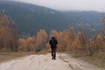 L'uomo cammina su un sentiero vuoto circondato da cespugli — Foto stock