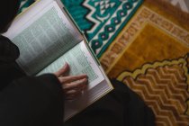 Крупный план мусульманки, читающей священный Коран — стоковое фото