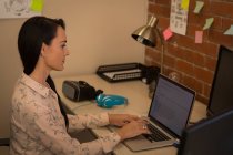 Executivo feminino usando laptop na mesa no escritório — Fotografia de Stock
