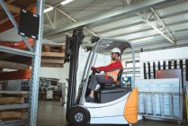 Male worker driving forklift in the warehouse — Stock Photo