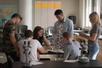 Lehrer unterstützt Schüler bei Experimenten mit Molekülen im Labor — Stockfoto