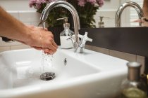 Close-up of man washing his hands in sink — Stock Photo