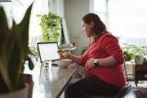 Pregnant woman having breakfast while using laptop at home — Stock Photo