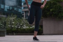 Sportliche Frau streckt sich auf der Straße — Stockfoto