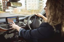 Schöne weibliche Führungskraft mit Navigation während des Autofahrens — Stockfoto