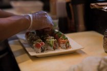 Chef guarnire affettato sushi in cucina contatore — Foto stock