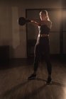 Frau macht Übungen mit Kettlebell im Fitnessstudio — Stockfoto