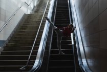 Танцовщица с улицы на эскалаторе на вокзале — стоковое фото