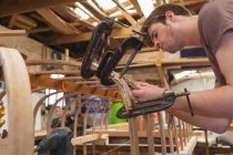 Молодой плотник работает в мастерской — стоковое фото