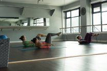 Gruppo di atleti in forma che praticano yoga in palestra
. — Foto stock