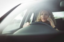 Close-up de executivo feminino falando no telefone celular enquanto dirige um carro — Fotografia de Stock