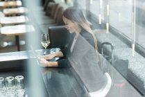 Бізнес-леді сидить наодинці, використовуючи цифровий планшет у вестибюлі — стокове фото