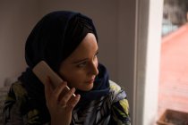 Muslim woman talking on the phone at home — Stock Photo