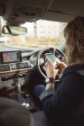 Rückansicht weiblicher Führungskräfte mit Handy im Auto — Stockfoto