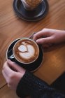 Frau mit Cappuccino am Tisch in Café überfallen — Stockfoto