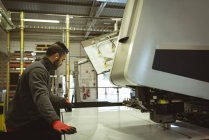 Trabalhador masculino verificando uma folha de vidro na fábrica — Fotografia de Stock