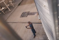 Visão de alto ângulo do homem usando tablet digital na fábrica — Fotografia de Stock