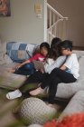 Матері та діти мають Відеодзвінок на ноутбуці у вітальні на дому — стокове фото
