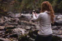 Visão traseira da mulher tirando foto da montanha com telefone celular — Fotografia de Stock