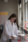 Дівчина-підліток експериментує з хімією в лабораторії в університеті — стокове фото