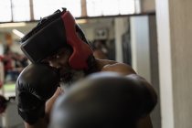 Determined senior man boxing in fitness studio. — Stock Photo