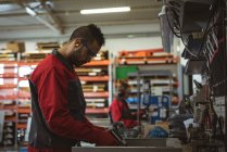 Чоловік працівник ремонтує машину з інструментом на заводі — стокове фото