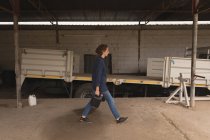 Arbeiterin läuft mit Dose in der Werkstatt — Stockfoto