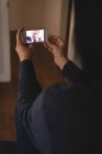 Жінка має відеодзвінок на мобільний телефон вдома — стокове фото