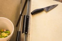 Gros plan du couteau de cuisine sur la planche à découper — Photo de stock