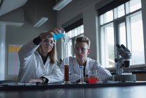 Étudiants universitaires en expérience chimique au laboratoire — Photo de stock