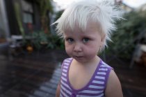 Close-up of toddler girl standing in wet porch at home. — Stock Photo